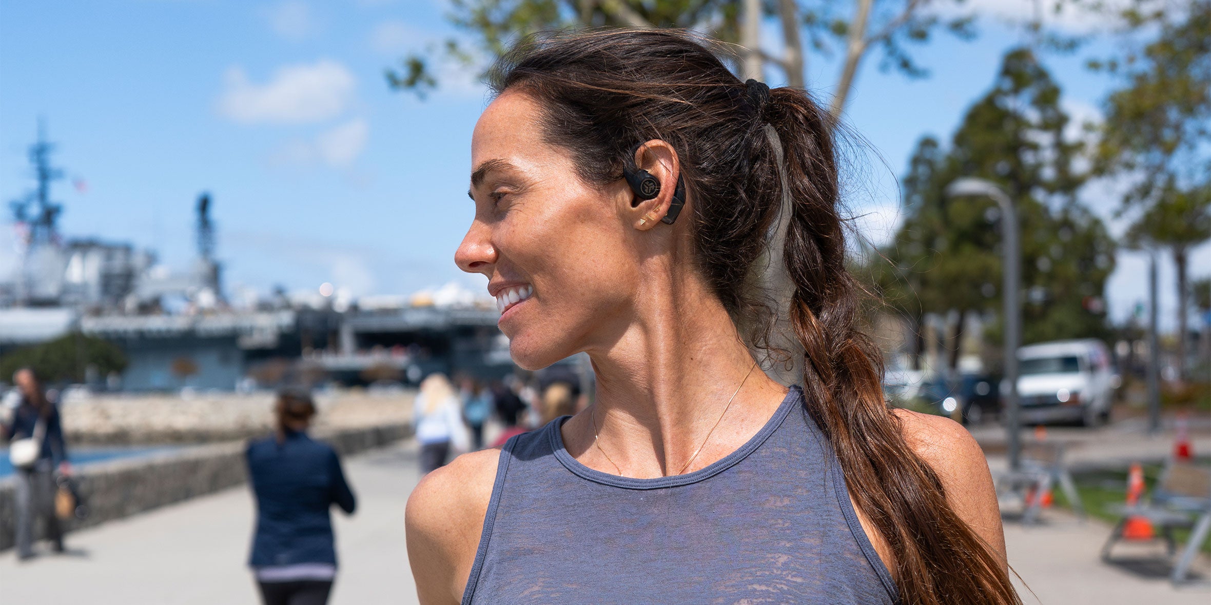 A woman using her safe listening feature on JLab Epic Open Sport
