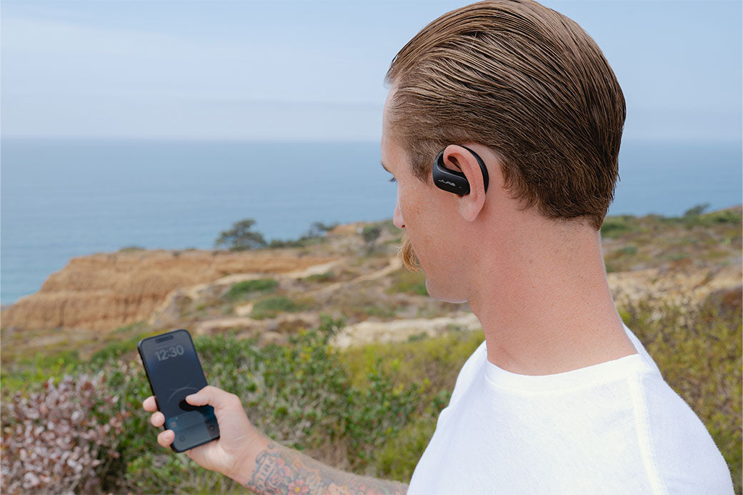 Man wearing JBuds Open Sport while taking a call outside