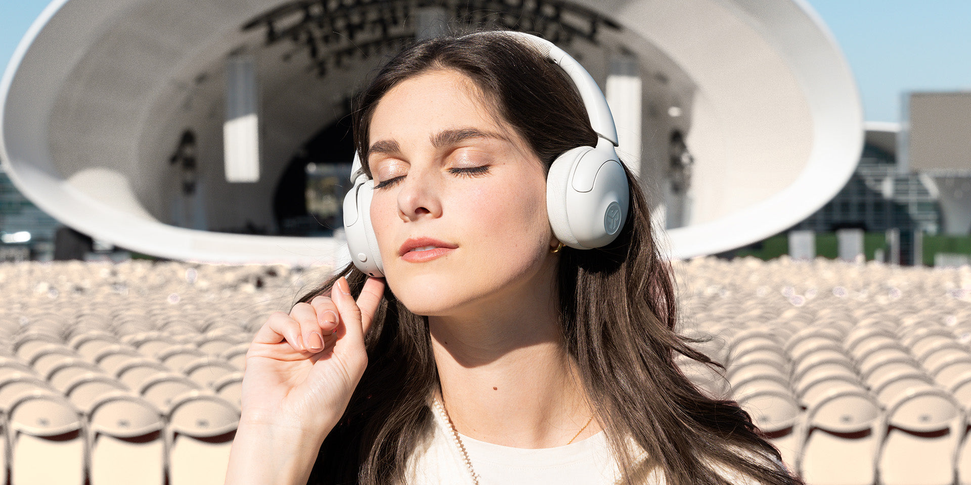 A woman enjoys noise canceling on her white headphones.