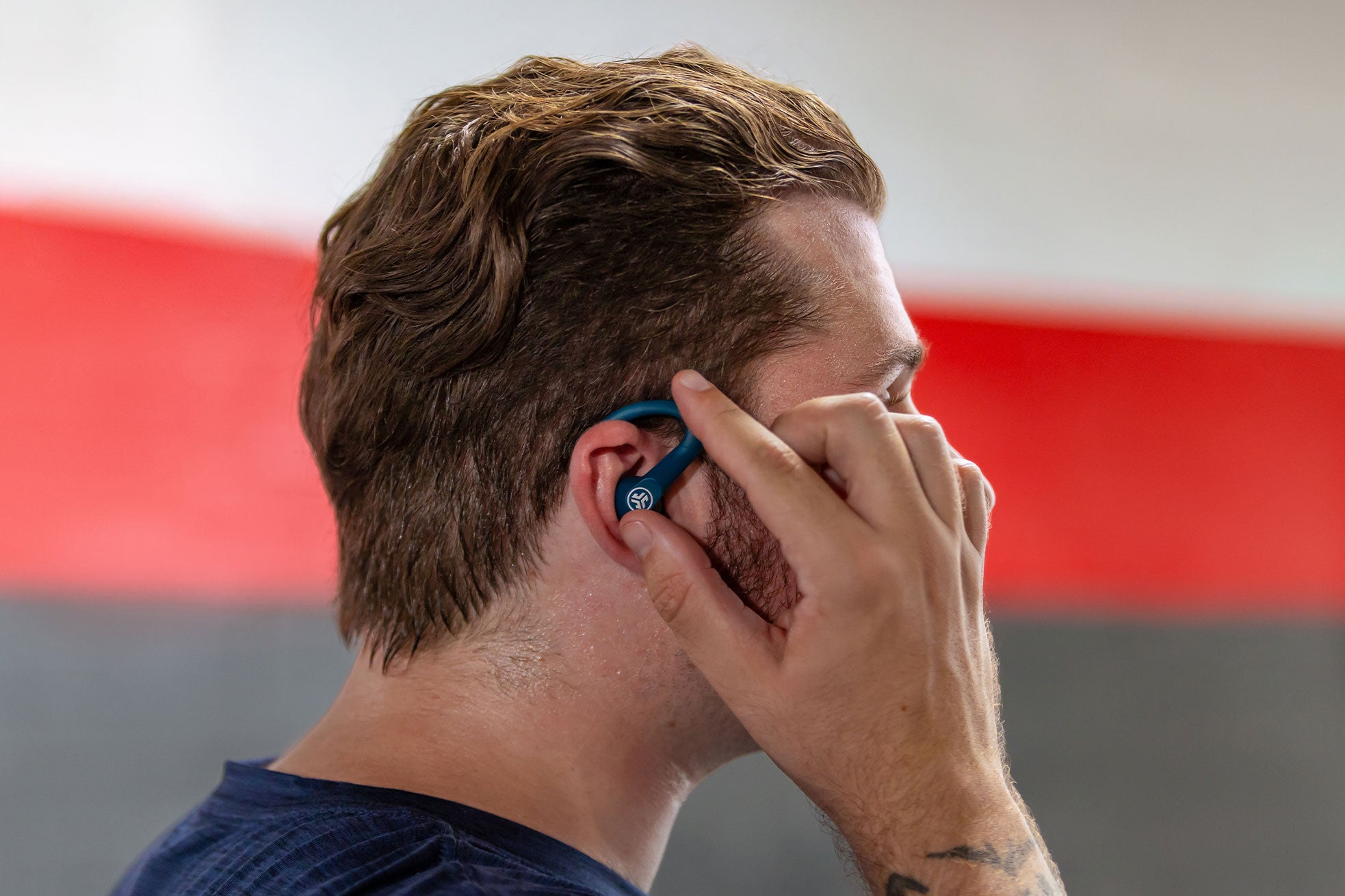 A man connecting to his blue Go Sport ANC earbuds