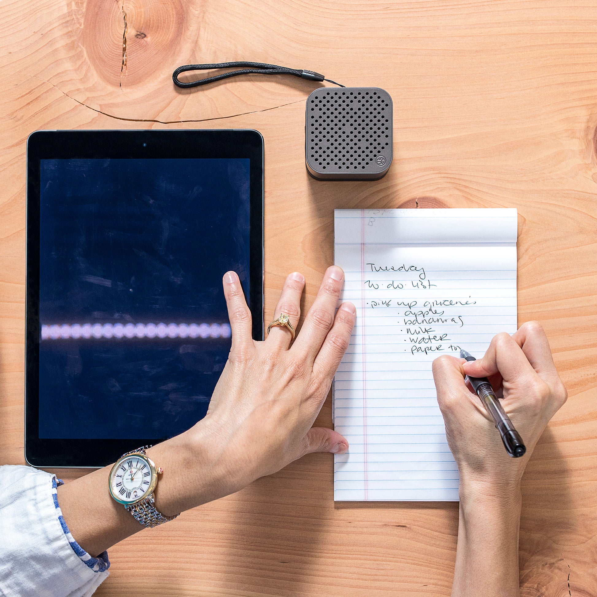 Gunmetal Crasher Micro Speaker on Desk Next to Woman Writing